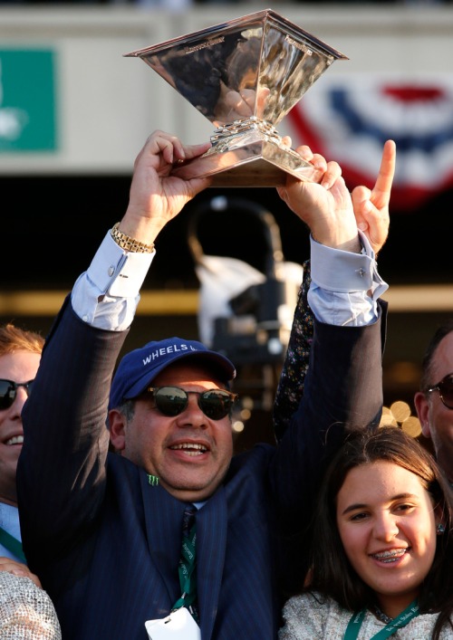 Ahmed Zayat holds up the Triple Crown Trophy after American Pharoah won the 147th running of the Belmont Stakes horse race at Belmont Park, Saturday, June 6, 2015, in Elmont, N.Y. American Pharoah is the first horse to win the Triple Crown since Affirmed won it in 1978.(AP Photo/Kathy Willens)